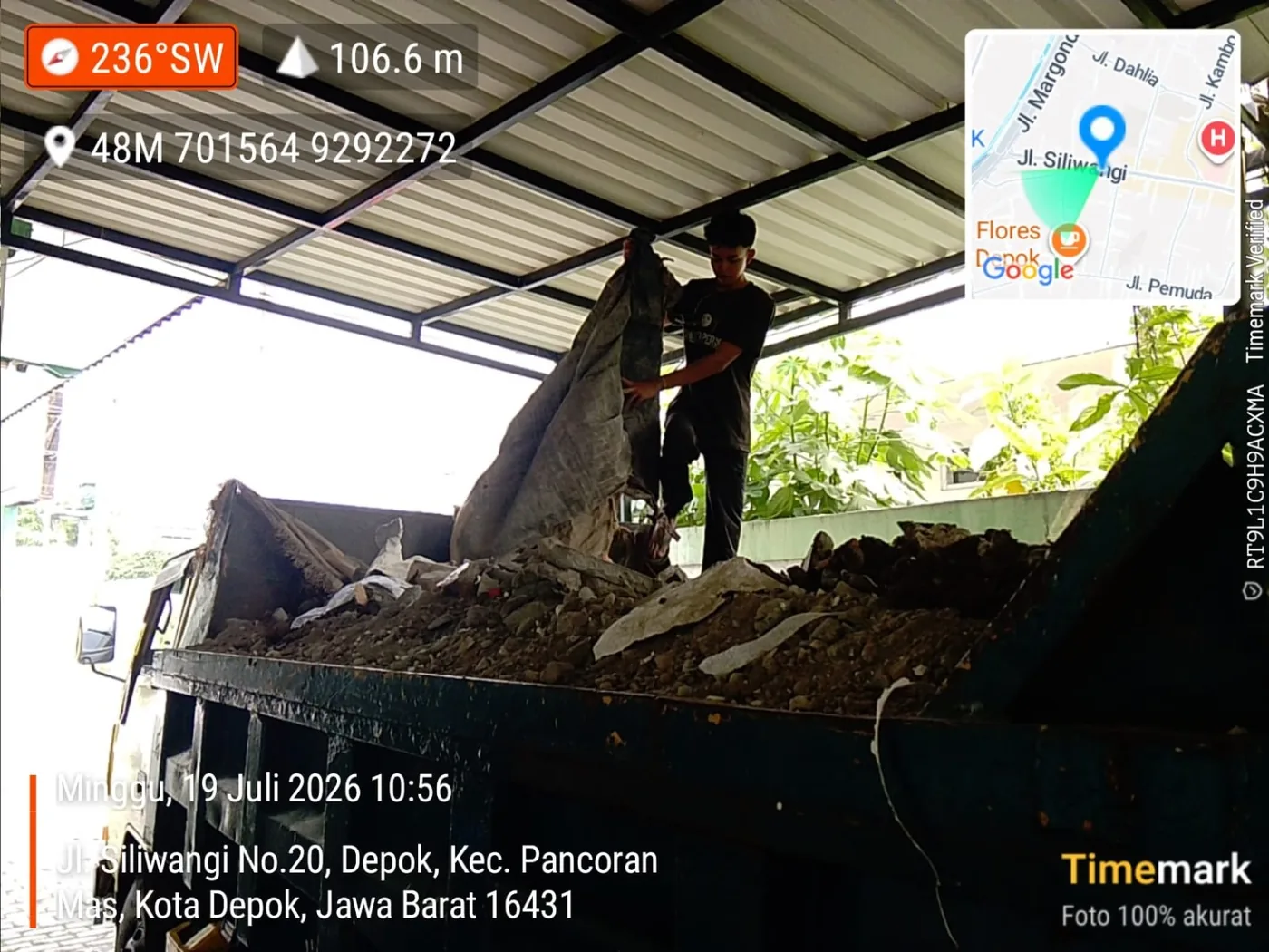 Pekerja memasukkan tanah dan material galian ke dalam bak truk