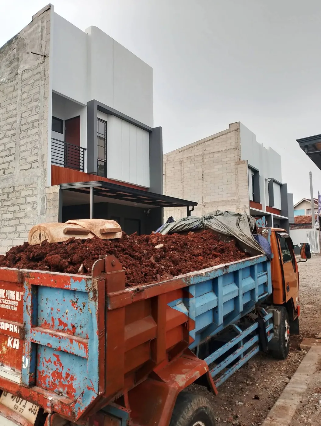 Truk membawa muatan tanah merah untuk kebutuhan pengurugan lahan