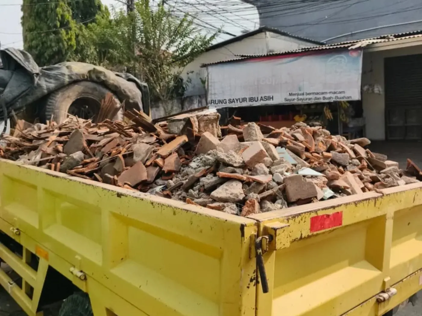 Truk mengangkut puing bata dan material bongkaran